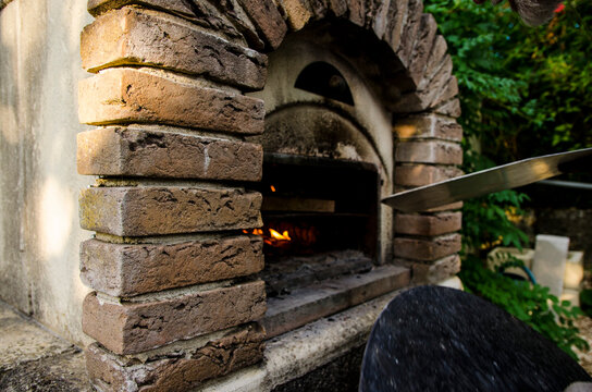 Holzofen ge&ouml;ffnet mit Feuer und Schieber