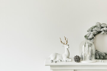 Christmas composition on the white chimney at the living room interior with beautiful decoration. Christmas tree and wreath, candles, stars, light. Copy space. Template.