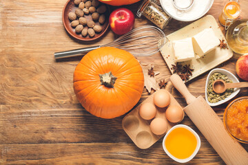 Ingredients for preparing pumpkin pie on wooden background
