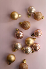 Christmas baubles in gold and pink tones. Top view, pink background.