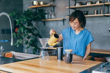 キッチンでコーヒーをいれる女性

