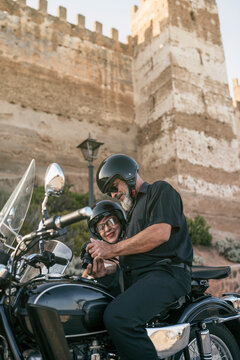 Ba&ntilde;os de la Encina, Jaen, Spain Senior couple on sidecar review camera images near to the castle.