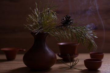 Still life with branch of pine tree and two cups of tea.