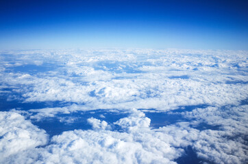 비행기 창문을 통해서 본 하얀 구름이 떠 있는 파란 하늘