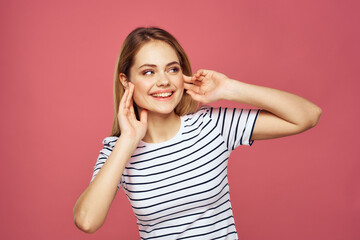 Cheerful woman striped t-shirt lifestyle emotions and gestures with hands pink background 