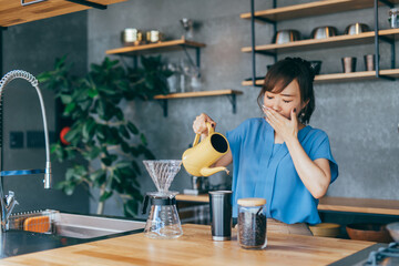 キッチンでコーヒーをいれる女性
