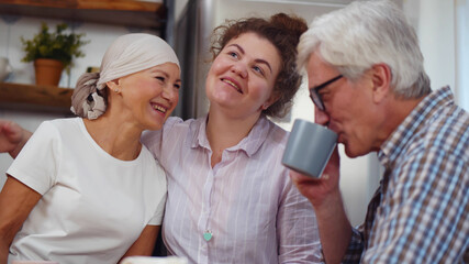 Senior woman after chemo having breakfast with daughter and husband at home