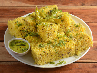Indian Gujarati Khaman Dhokla made using Dal, served with Green chutney, selective focus