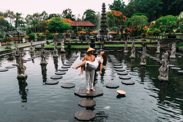 A beautiful couple is traveling on the island of Bali in Indonesia. A couple walks through a water...