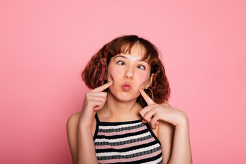 Image of young happy beautiful woman posing isolated over pink wall background. woman grimace