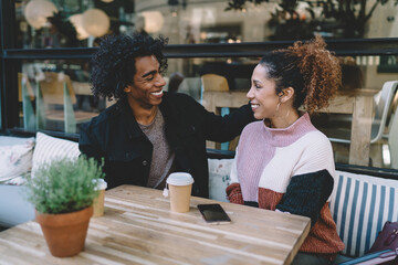 Happy young couple smiling to each other in cafe
