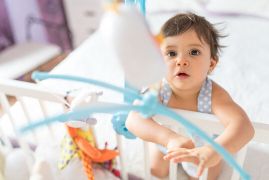 adorable toddler one year old in bedroom crib