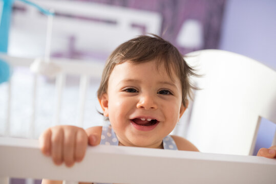 adorable toddler one year old in bedroom crib