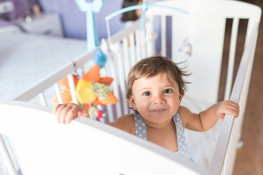 adorable toddler one year old in bedroom crib
