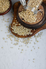 Pine nuts in a glass jar on wooden boards on a concrete background. Forest delicacies.