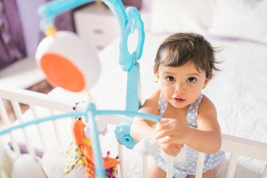 adorable toddler one year old in bedroom crib