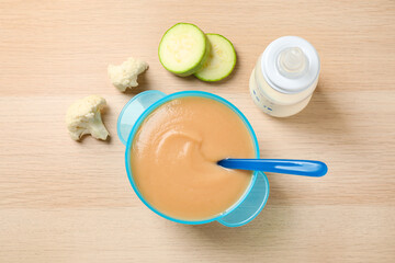 Healthy baby food and ingredients on wooden table, flat lay