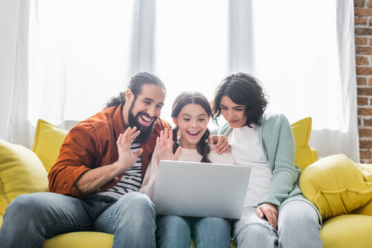 Happy Hispanic Family Waving Hands While Having Videocall On Laptop