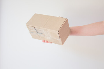 Сourier delivered the package and hands it over to the recipient. Cardboard box with parcel in the hands of a satisfied recipient. Concept of delivery time of goods, fast delivery