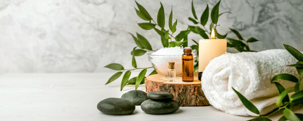 beauty treatment items for spa procedures on white wooden table. massage stones, essential oils and sea salt. copy space - obrazy, fototapety, plakaty