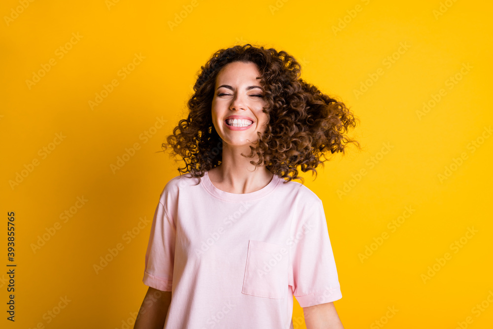 Wall mural Photo portrait of smiling happy woman with closed eyes isolated on vivid yellow colored background