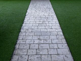 stone pathway on green artificial grass of lawn