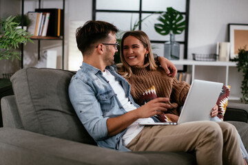 Happy young couple with laptop at home.