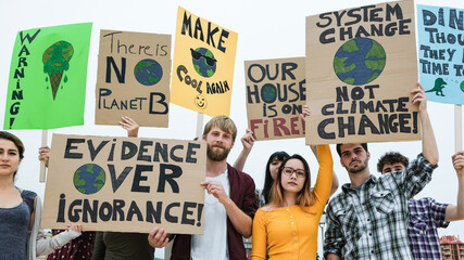 Group of demonstrators on road, young people from different culture and race protest for climate change - Global warming and enviroment concept - Focus on banners