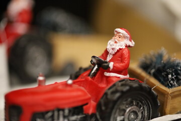 Portrait of Santa Claus drives on the red tractor, Christmas holidays, blurred background, copy space