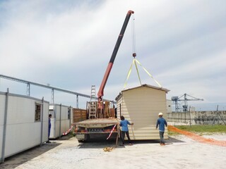 The Hiab is lifting the cabinet to the ground.