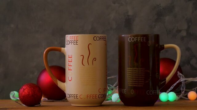 Steaming Christmas coffee cups bokeh lights decoration. Winter holidays music background, cozy home good morning concept, New year festive song. Two mugs with hot tea drink. Love romance couple date.