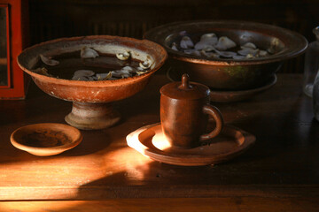 Various handicrafts come from clay such as mug, bowl, plate and tray on wooden table