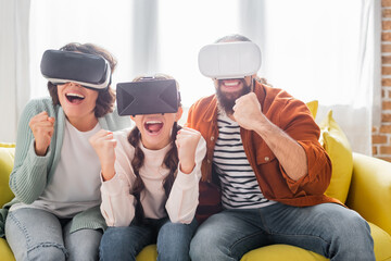 excited hispanic family showing winner gesture while using vr headsets