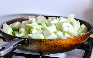 Vegetable squash stew is prepared in a cast-iron pan. Country lifestyle. Food background.