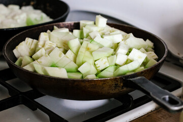 Vegetable squash stew is prepared in a cast-iron pan. Country lifestyle. Food background.