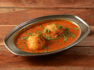 Anda Masala or Egg Curry is popular indian spicy food, served in a ceramic bowl over rustic wooden background. Selective focus