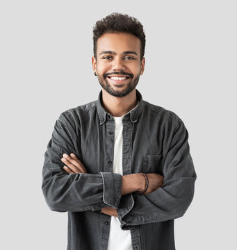 Handsome Smiling Young Man Portrait, Laughing Joyful Businessman With Crossed Arms Studio Shot, Male Model, Isolated On Gray Background