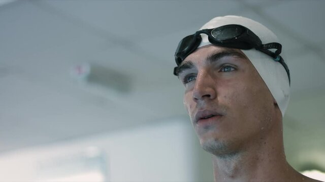Slow motion video of young swimmer preparing for swim and training some swimming techniques. Portrait shot.