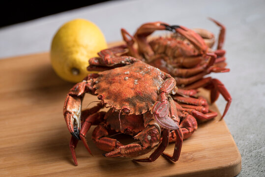 Delicious red crabs on a wooden board with a lemon