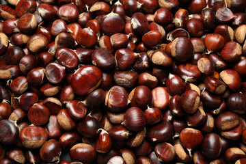 Top view of fresh edible sweet chestnuts as background, closeup