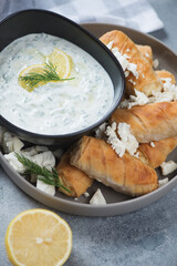 Close-up of greek mini feta rolls with tzatziki sauce, selective focus, vertical shot