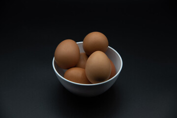 Huevos en un bol de plastico blanco sobre fondo negro