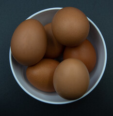 Huevos en un bol de plastico blanco sobre fondo negro