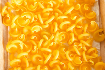 Yellow pasta as a background image. Top view. Copy, empty space for text
