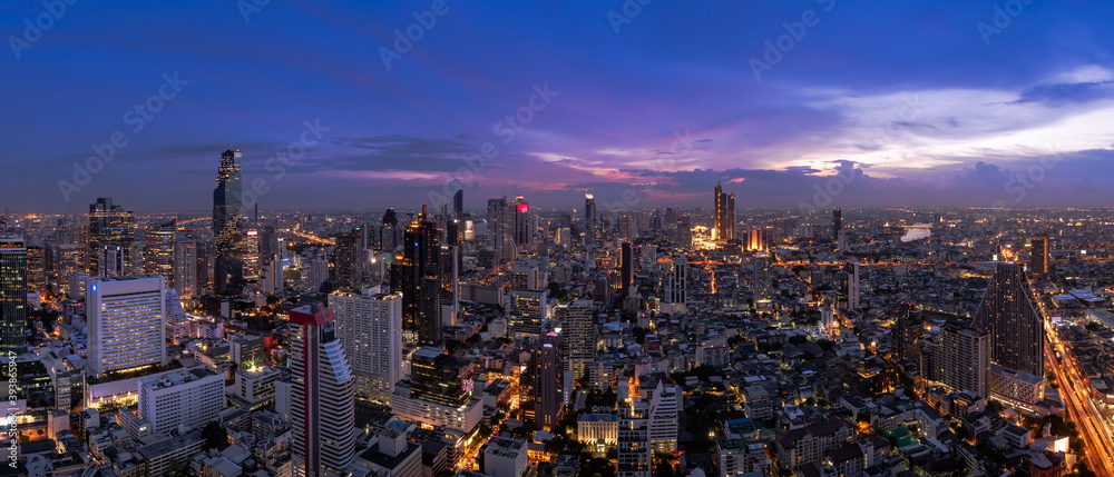 Wall mural bangkok business district cityscape with skyscraper at twilight, thailand - panorama