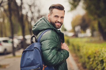 Photo of satisfied bearded person turn head to camera toothy smile good vibes carry blue bag...