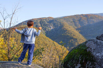 Child boy observing waterfall at Natural Reserve Garganta de los Infiernos, Extremadura, Spain
