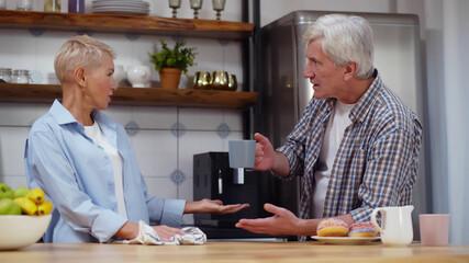 Portrait of angry mature couple quarrel at home kitchen