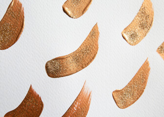 gold paint strokes with glitter on white watercolor paper. sharpness in the center of the frame. Golden color