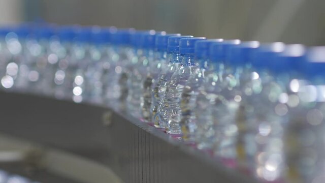 Conveyor line with PET bottles. Industrial equipment. Factory for bottling water and drinks.